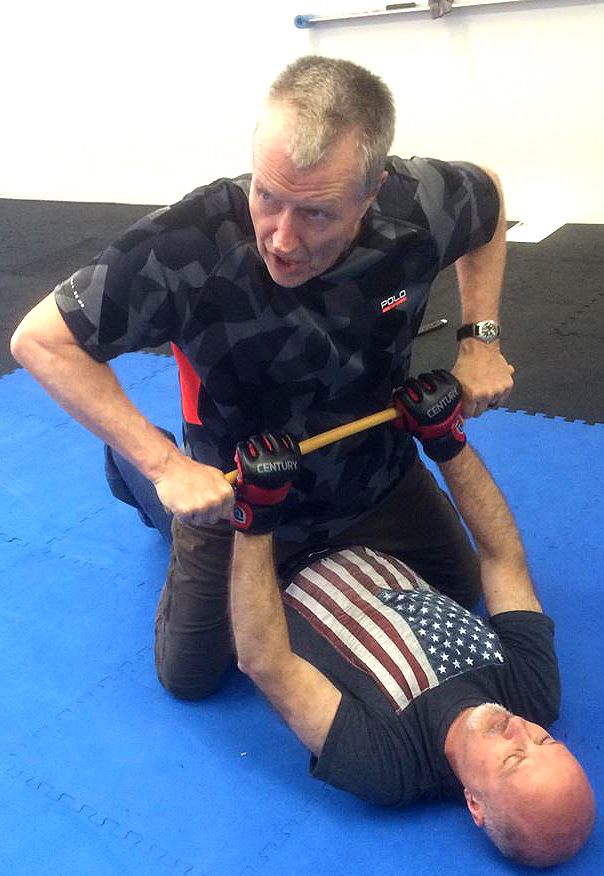 Hock in a top mounted position over his partner, each with both hands on the Arnis stick.