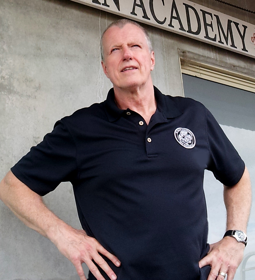 W. Hock Hochheim looking off into the distance in front of a training academy in Australia.