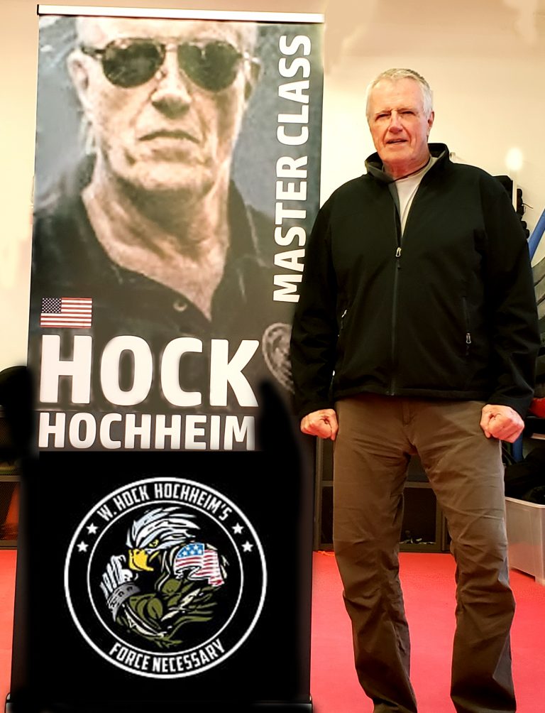W. Hock Hochheim standing next to a seminar banner.